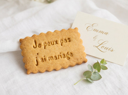Biscuits personnalisés avec message pour mariage, posés sur une table de réception